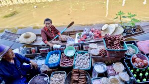 Food vendors at Damnoen Saduak Floating Market offering tasty treats on our Maeklong Railway and Floating Market Tour from Bangkok